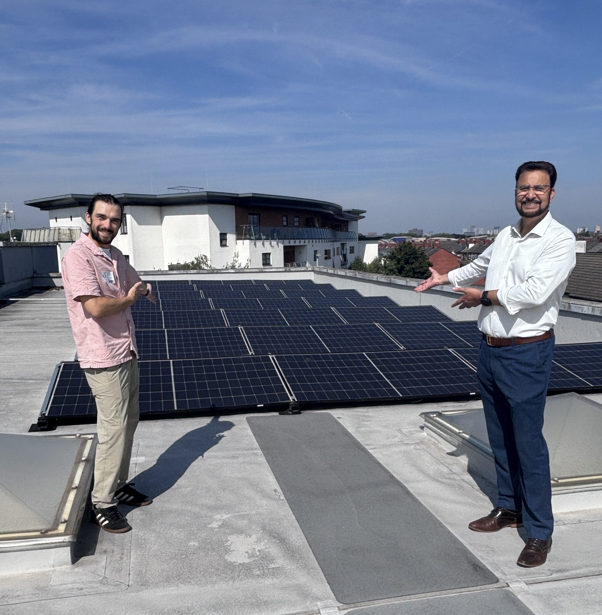 Photograph of GMCR Director Tudor Baker and Afzal Khan MP posing with solar panels at Divine Mercy Primary School
